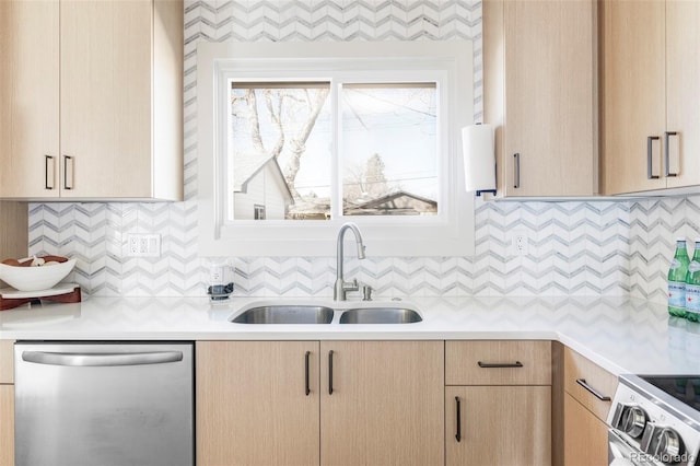 kitchen featuring light countertops, decorative backsplash, appliances with stainless steel finishes, light brown cabinets, and a sink