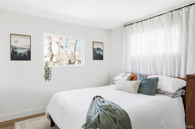 bedroom featuring baseboards and wood finished floors