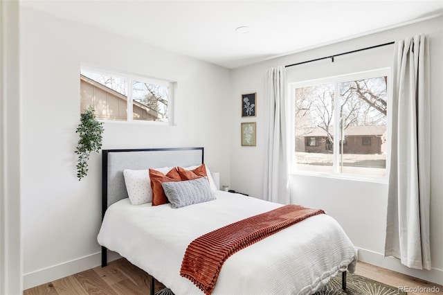 bedroom with baseboards and wood finished floors