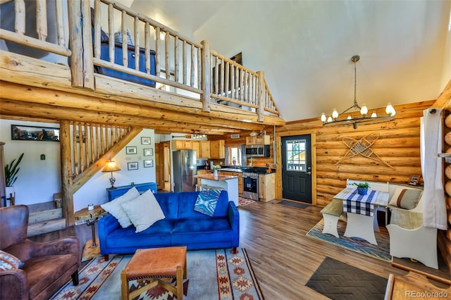 living room featuring high vaulted ceiling, wood-type flooring, an inviting chandelier, and rustic walls