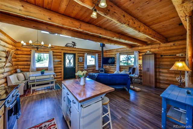 interior space with an inviting chandelier, beamed ceiling, dark wood-type flooring, and plenty of natural light