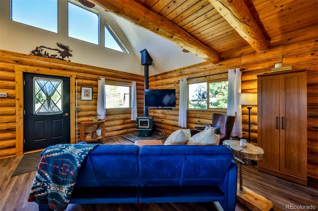 living room featuring a wood stove, beam ceiling, plenty of natural light, and dark hardwood / wood-style flooring