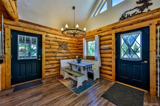 foyer featuring log walls, lofted ceiling, a chandelier, and dark hardwood / wood-style floors