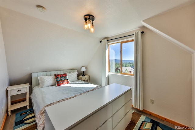 bedroom with dark wood-type flooring and lofted ceiling