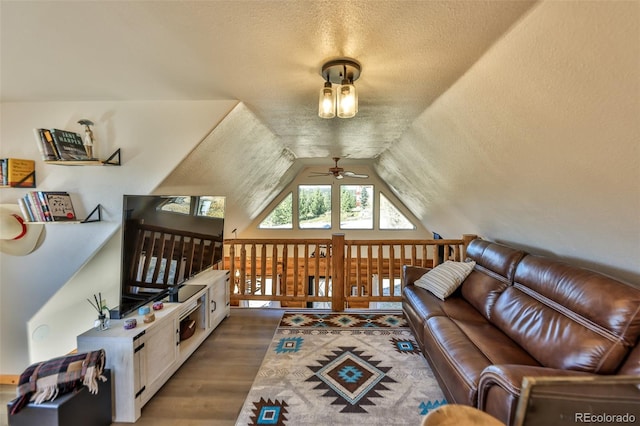 living room with lofted ceiling, dark wood-type flooring, a textured ceiling, and ceiling fan