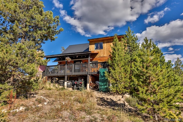 rear view of property featuring a wooden deck