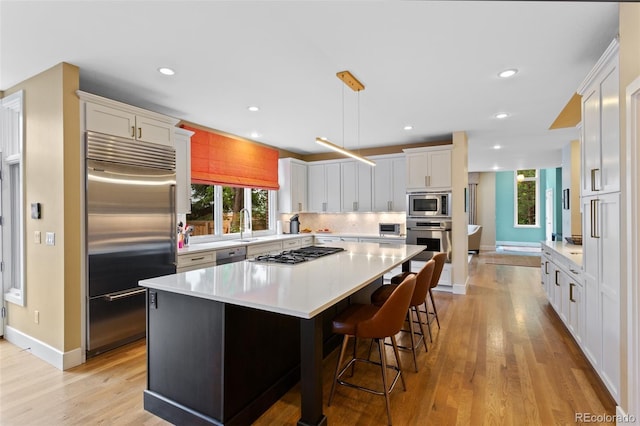 1479 S Clarkson St, Denver, CO 80210 - kitchen with built in appliances, light wood-type flooring, decorative backsplash, light countertops, and recessed lighting