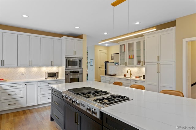 1479 S Clarkson St, Denver, CO 80210 - kitchen with appliances with stainless steel finishes, white cabinetry, backsplash, glass insert cabinets, and recessed lighting