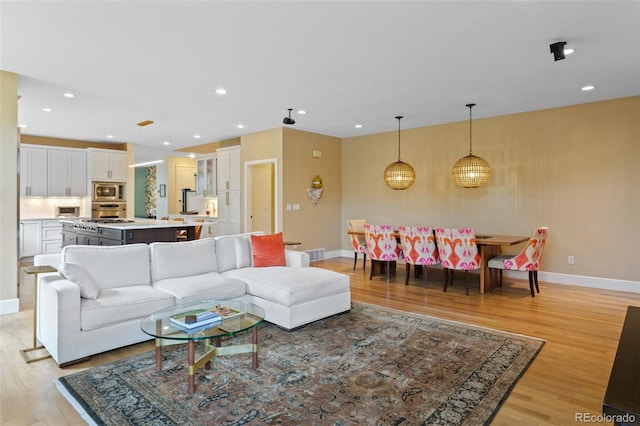 1479 S Clarkson St, Denver, CO 80210 - living room featuring light wood-type flooring and recessed lighting