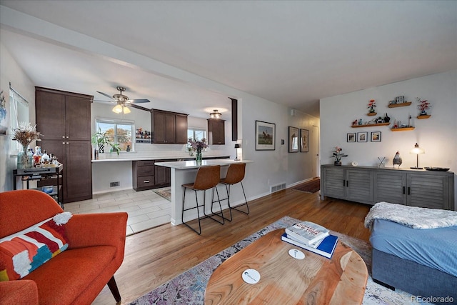 living room featuring ceiling fan and light hardwood / wood-style flooring