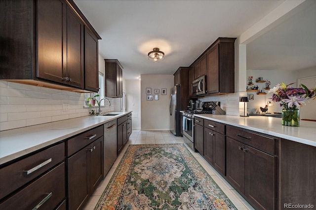 kitchen with backsplash, appliances with stainless steel finishes, sink, and dark brown cabinets