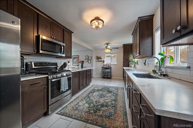 kitchen featuring dark brown cabinets, stainless steel appliances, sink, and backsplash