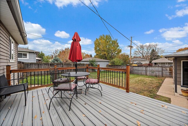 wooden terrace featuring a lawn