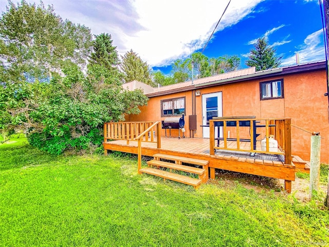 rear view of house with a lawn and a wooden deck