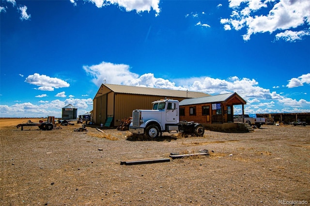 rear view of property with an outdoor structure