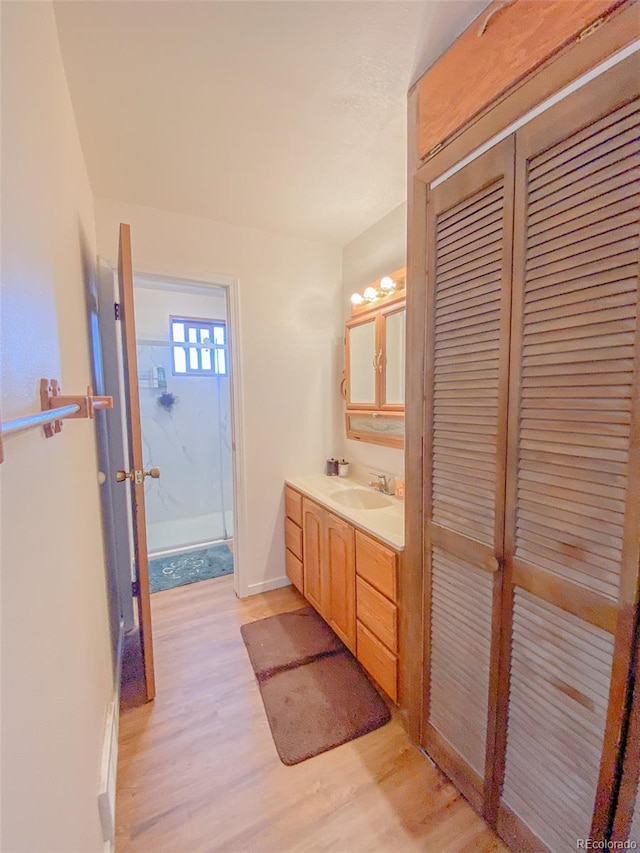 bathroom featuring walk in shower, vanity, and hardwood / wood-style flooring