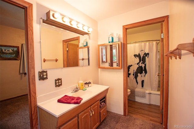 bathroom with wood-type flooring, vanity, and toilet