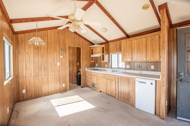 kitchen with a healthy amount of sunlight, lofted ceiling with beams, dishwasher, and wood walls