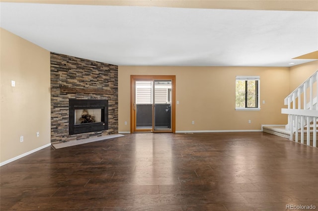 6730 W 84th Cir Unit 96, Arvada, CO 80003 - unfurnished living room featuring stairway, a stone fireplace, baseboards, and dark wood-style floors