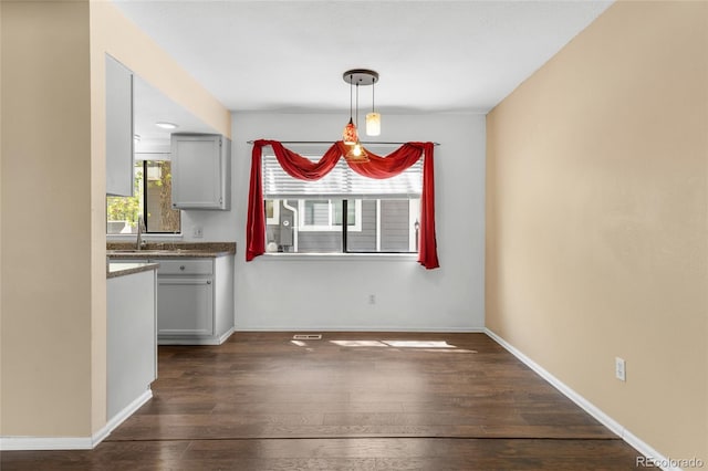 6730 W 84th Cir Unit 96, Arvada, CO 80003 - unfurnished dining area featuring dark wood finished floors, baseboards, and a sink