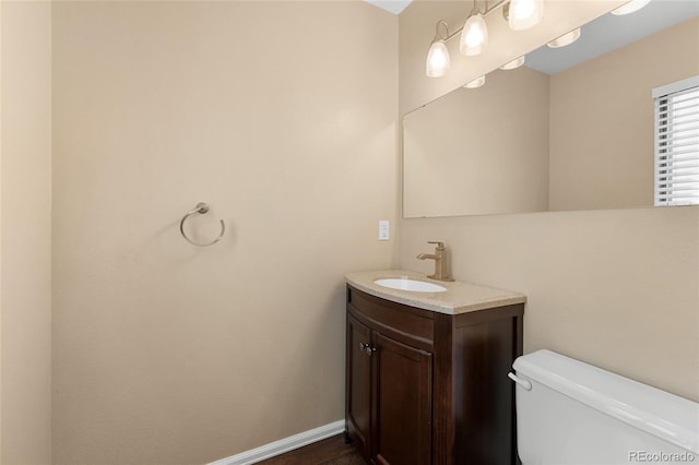 6730 W 84th Cir Unit 96, Arvada, CO 80003 - half bathroom featuring toilet, baseboards, and vanity