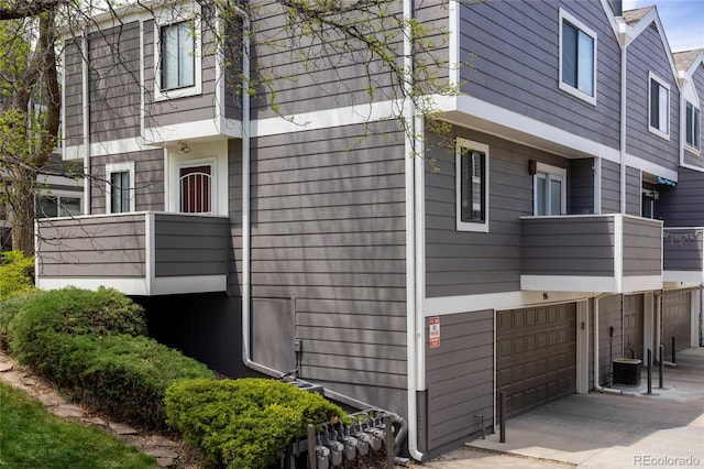 6730 W 84th Cir Unit 96, Arvada, CO 80003 - view of property exterior with concrete driveway, a garage, and a balcony