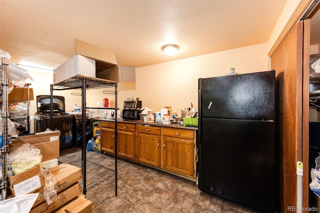 kitchen with a textured ceiling and black fridge