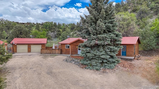114 Loop Dr, Howard, CO 81233 - log home with metal roof, an outbuilding, a garage, dirt driveway, and a forest view
