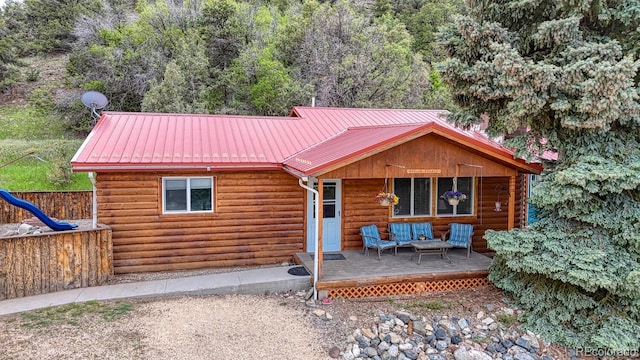 114 Loop Dr, Howard, CO 81233 - view of front of house with an outdoor hangout area, metal roof, a deck, and log veneer siding