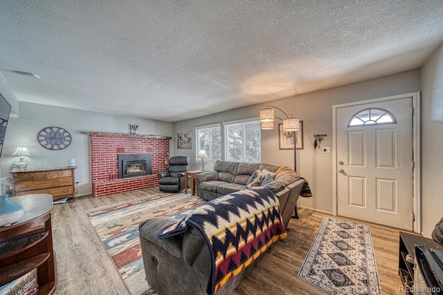 114 Loop Dr, Howard, CO 81233 - living room with wood finished floors, plenty of natural light, a textured ceiling, and a brick fireplace