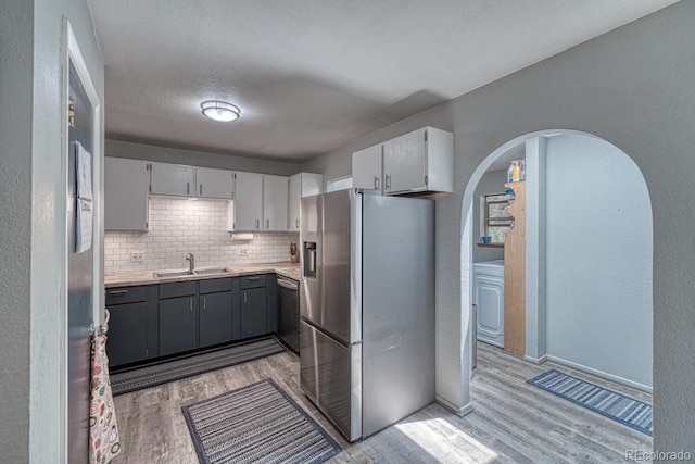 114 Loop Dr, Howard, CO 81233 - kitchen with stainless steel appliances, a sink, light wood-style flooring, decorative backsplash, and light countertops