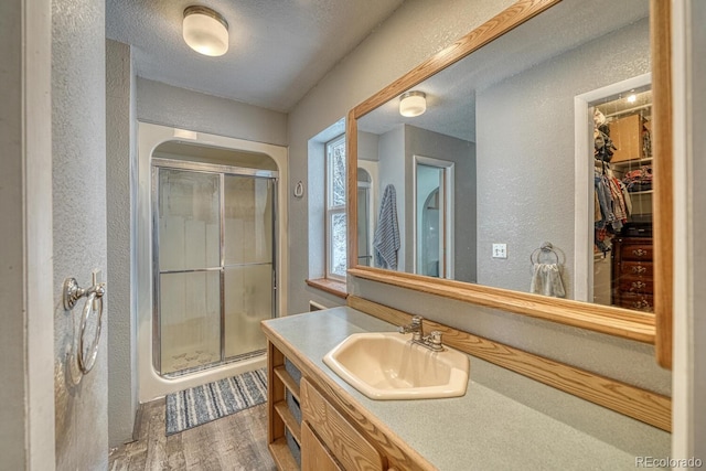 114 Loop Dr, Howard, CO 81233 - bathroom featuring a textured wall, a stall shower, wood finished floors, vanity, and a spacious closet