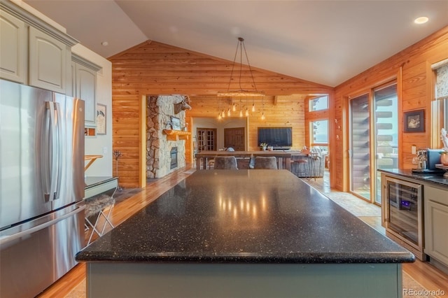 114 Gcr 4624, Grand Lake, CO 80447 - kitchen with freestanding refrigerator, wine cooler, wood walls, vaulted ceiling, and a fireplace