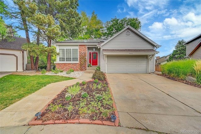 ranch-style home with roof mounted solar panels, concrete driveway, a front yard, a garage, and brick siding