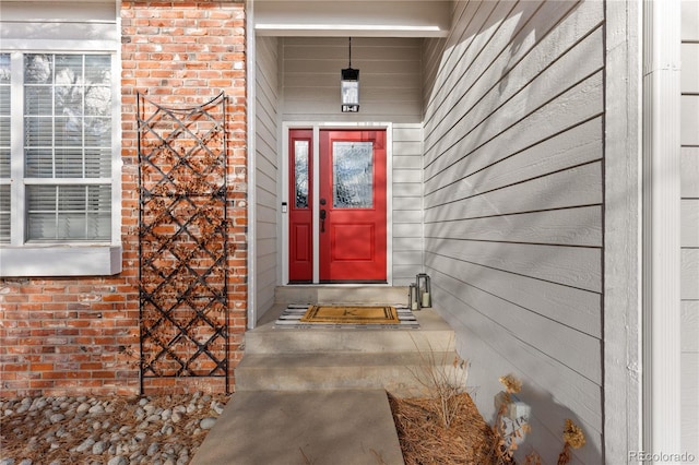 view of exterior entry featuring brick siding