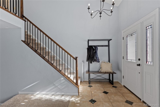 entrance foyer featuring tile patterned flooring, stairway, a towering ceiling, and a chandelier