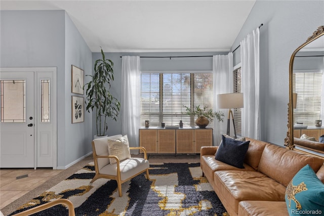 living room with baseboards, tile patterned flooring, and vaulted ceiling