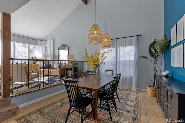 dining area with light tile patterned floors, high vaulted ceiling, and baseboards