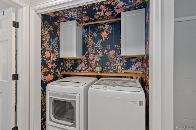 laundry room featuring cabinet space, washing machine and dryer, and wallpapered walls