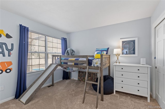 carpeted bedroom with a closet and baseboards