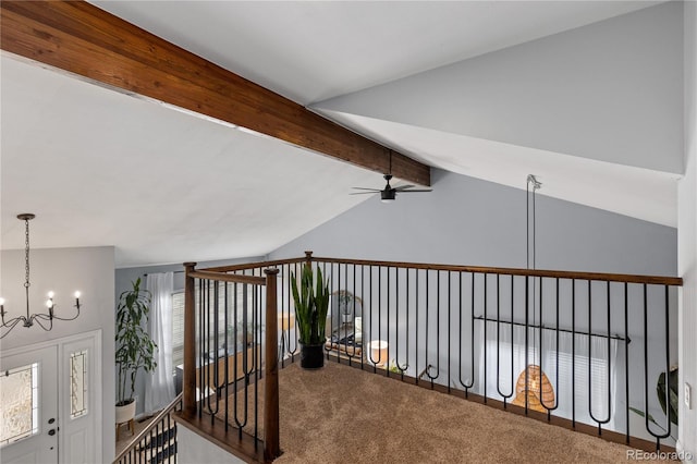 corridor with lofted ceiling with beams, carpet floors, and a notable chandelier