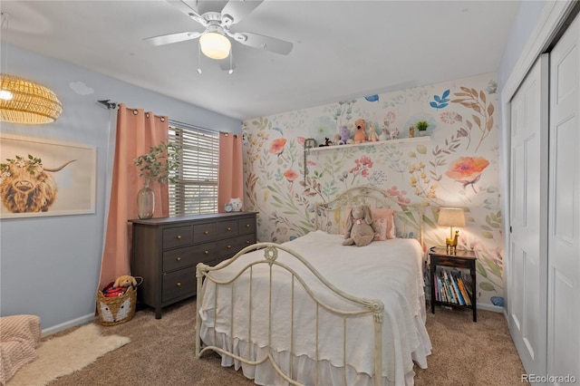 carpeted bedroom featuring wallpapered walls, baseboards, a closet, and ceiling fan