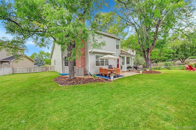 rear view of house featuring a patio area, a lawn, and a fenced backyard