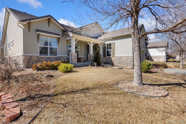 view of front of home with a porch, stone siding, and stucco siding