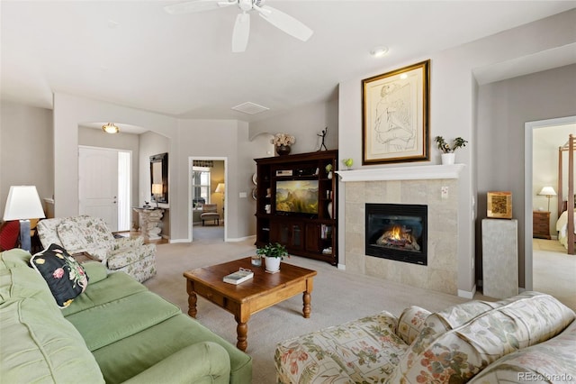 living room with visible vents, baseboards, a ceiling fan, light colored carpet, and a fireplace