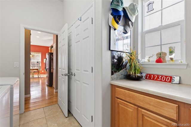 laundry room with laundry area, light tile patterned flooring, and washing machine and dryer