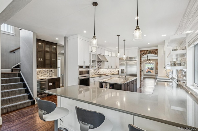 kitchen with open shelves, appliances with stainless steel finishes, decorative backsplash, dark wood-type flooring, and under cabinet range hood