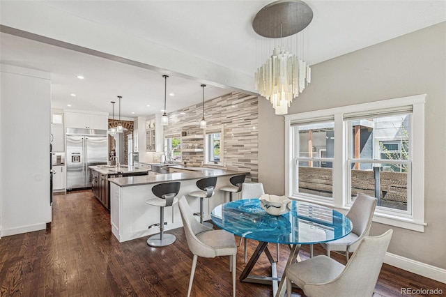 dining room with recessed lighting, baseboards, dark wood finished floors, and a notable chandelier