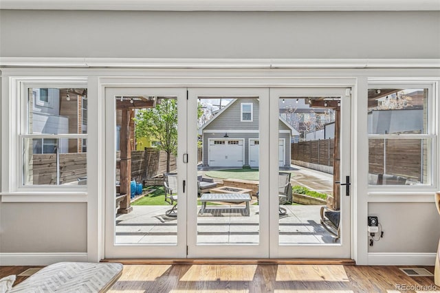 doorway to outside featuring baseboards, french doors, and wood finished floors