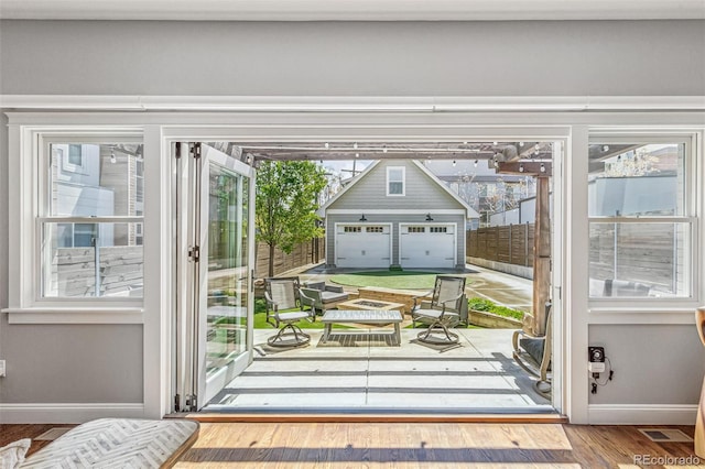 doorway to outside featuring baseboards, wood finished floors, and visible vents